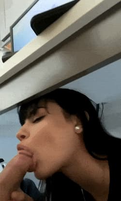 black haired hottie sneaks a blowjob from under a desk'